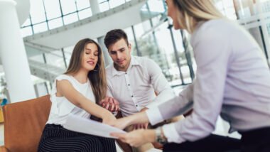 Financial,Advisor,Showing,Report,To,Young,Couple,For,Their,Investment.