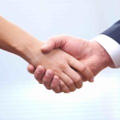 People at work: man and woman hand shaking at a meeting