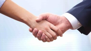 People at work: man and woman hand shaking at a meeting