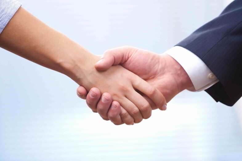 People at work: man and woman hand shaking at a meeting